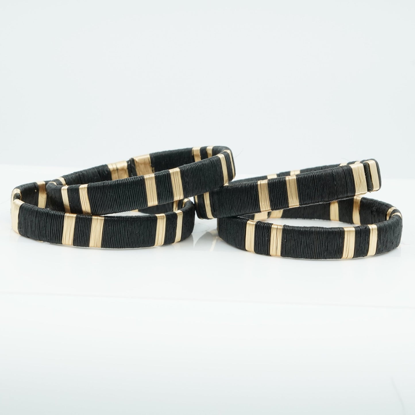 Bracelets made of black werregue palm fiber and gold wire.
