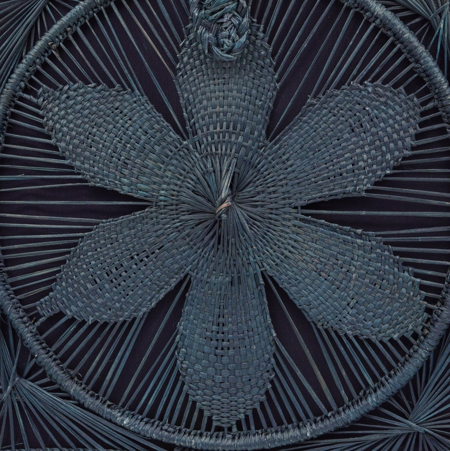 Close up view of blue woven square flower purse.