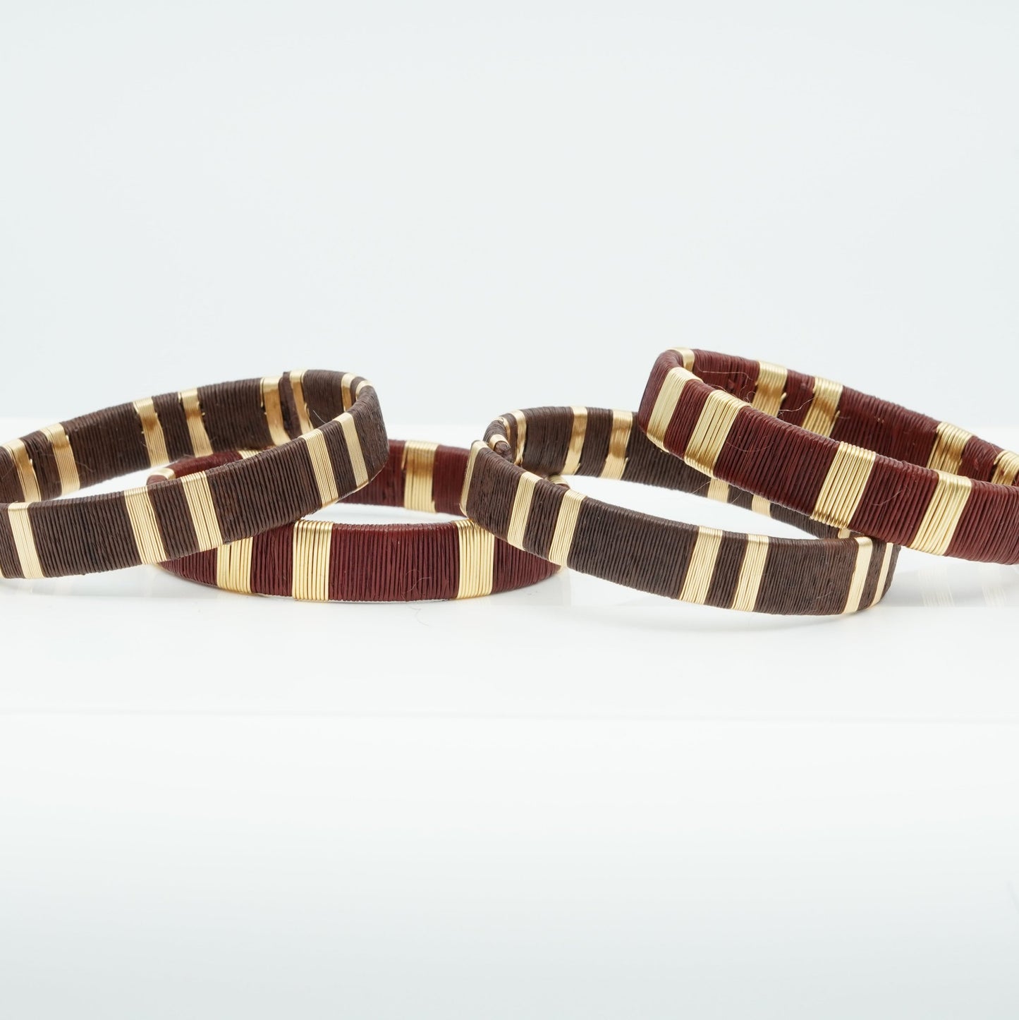 Bracelets made of brown werregue palm fiber and gold wire.