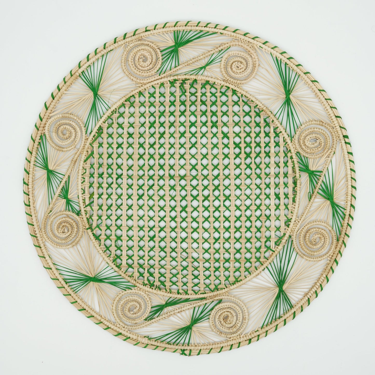 An overhead view of a woven placemat with a caracol (snail shell) pattern in natural and green.