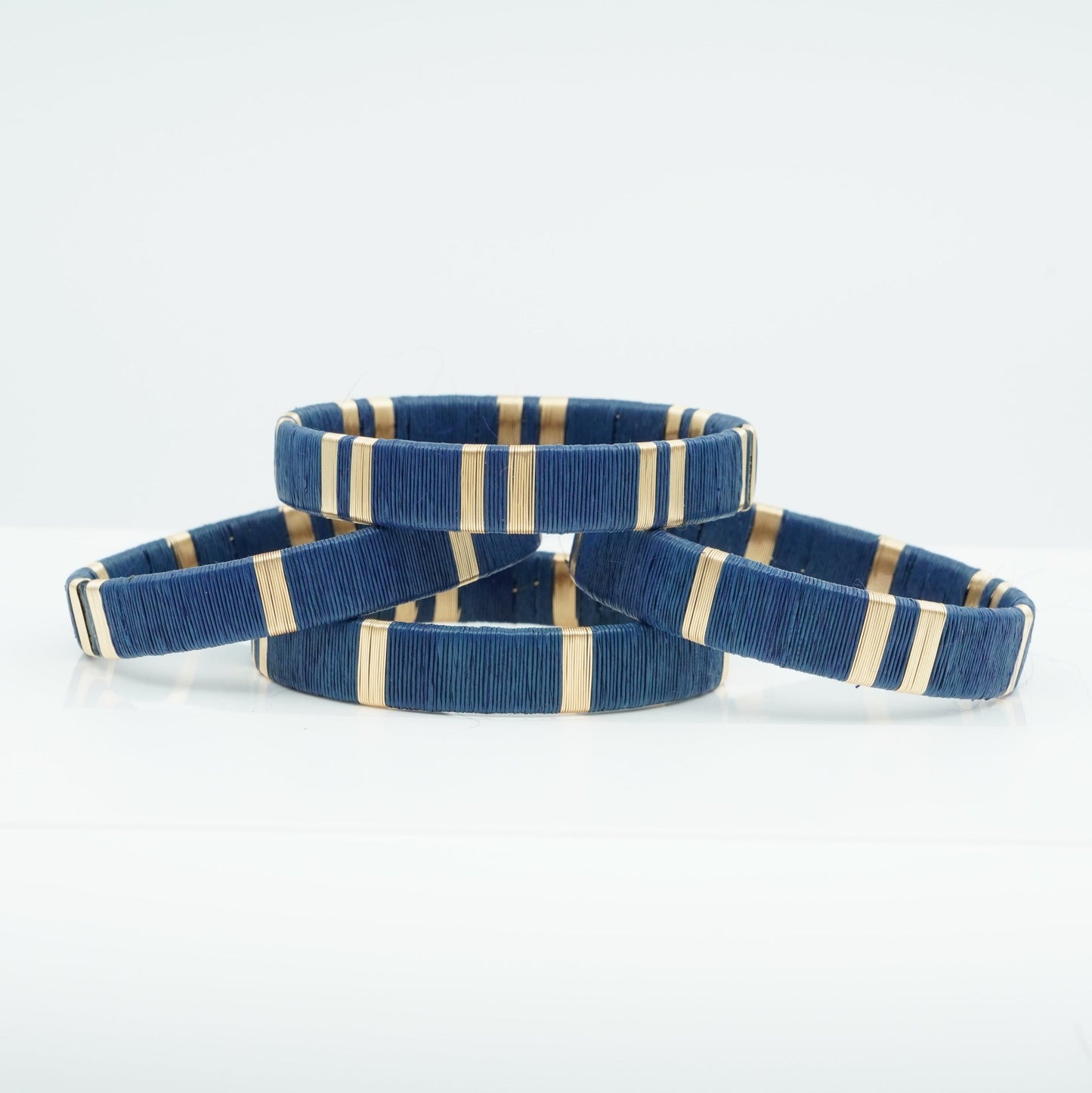 Bracelets made of dark blue werregue palm fiber and gold wire.