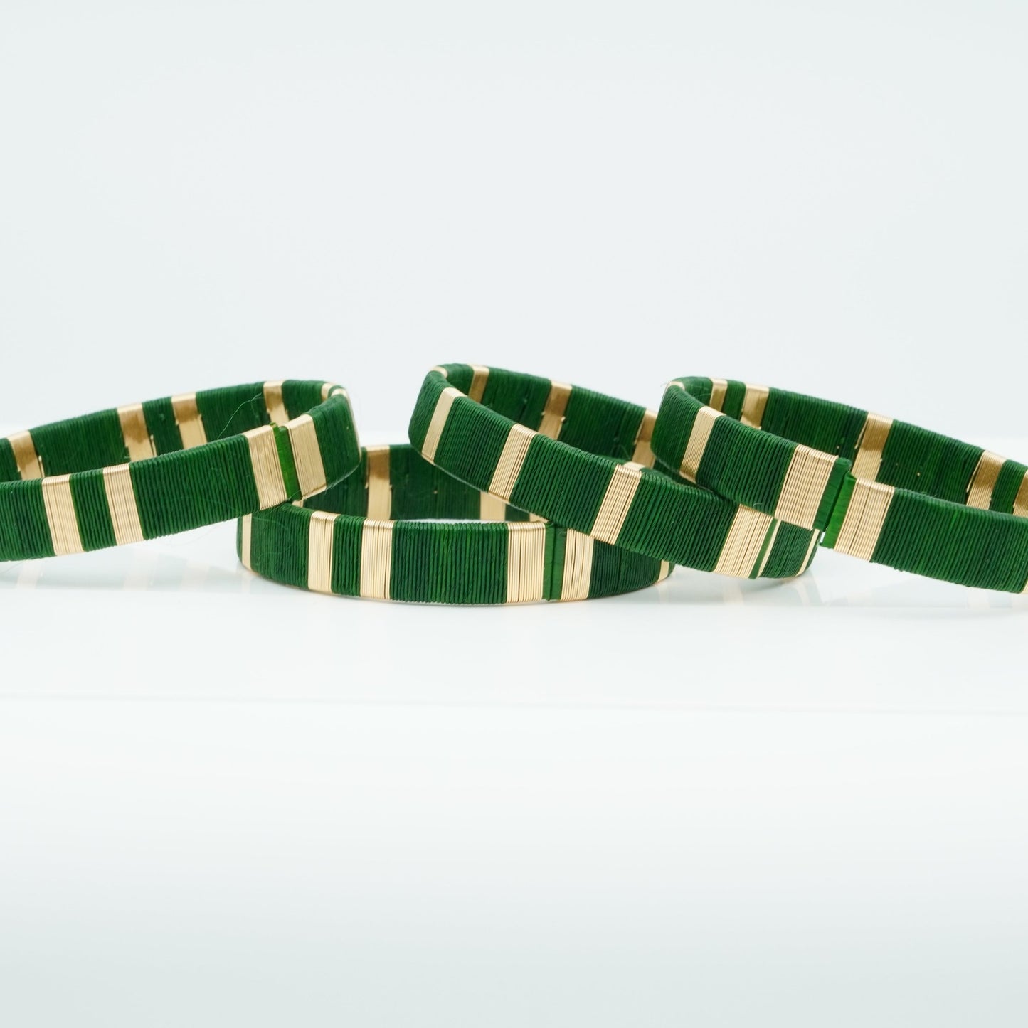 Bracelets made of dark green werregue palm fiber and gold wire.
