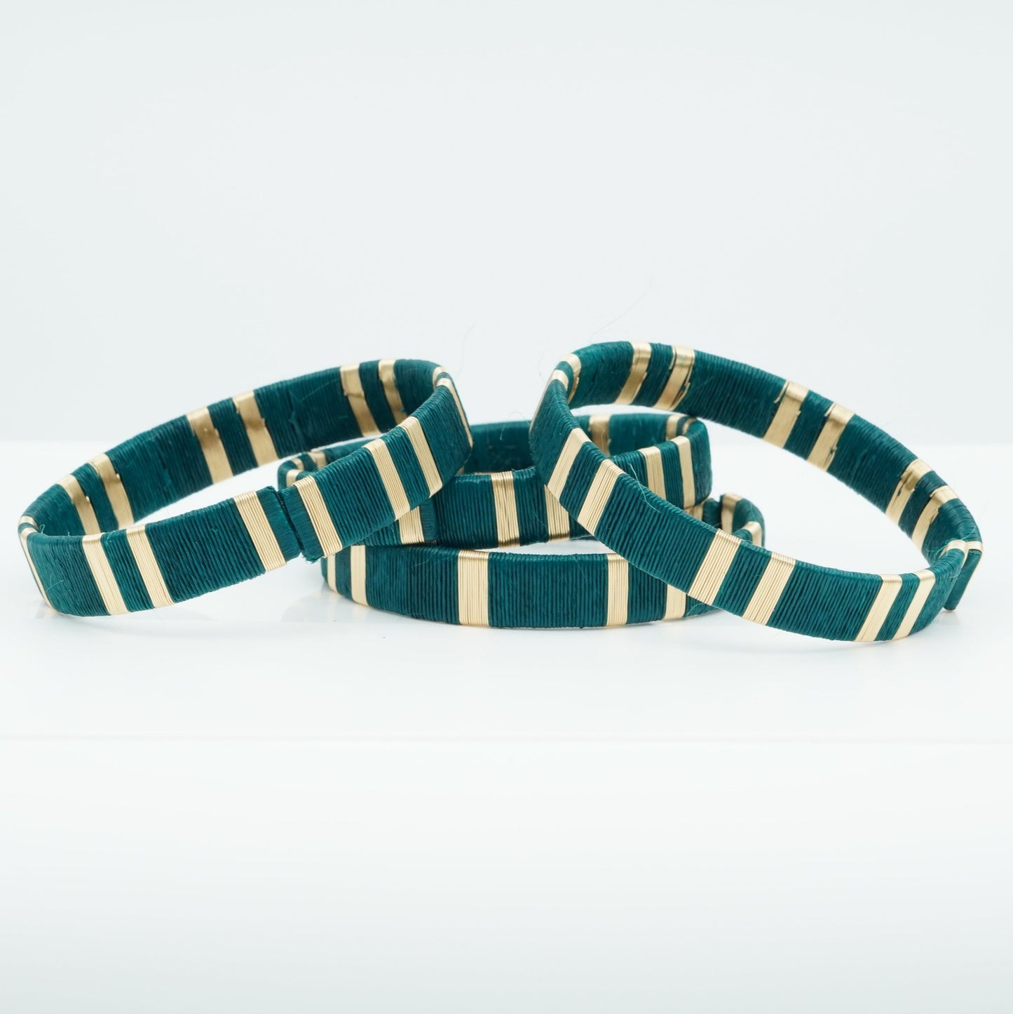 Bracelets made of deep aqua werregue palm fiber and gold wire.