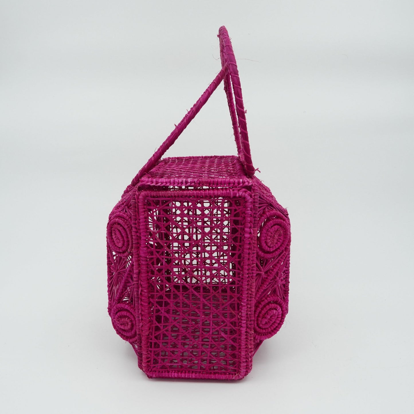 Side view of woven fuchsia lunchbox purse.