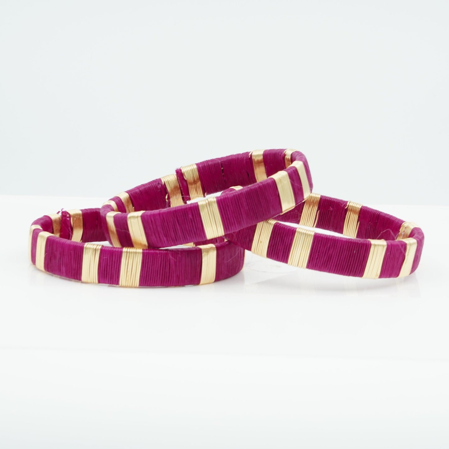 Bracelets made of fuschia werregue palm fiber and gold wire.