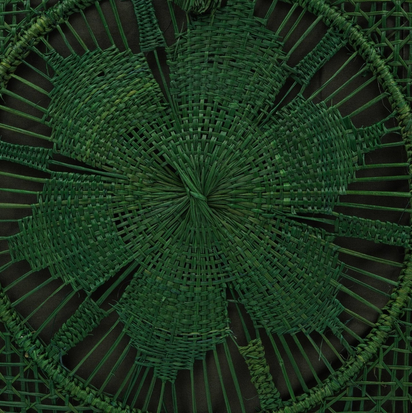 Close up view of green woven square flower purse.