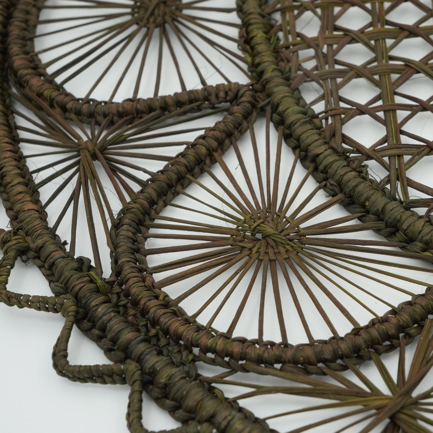 Close up view of half moon patterned woven placemat in olive green.