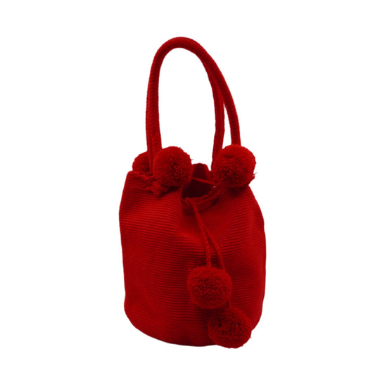 Large red mochila woven handbag with pompoms.