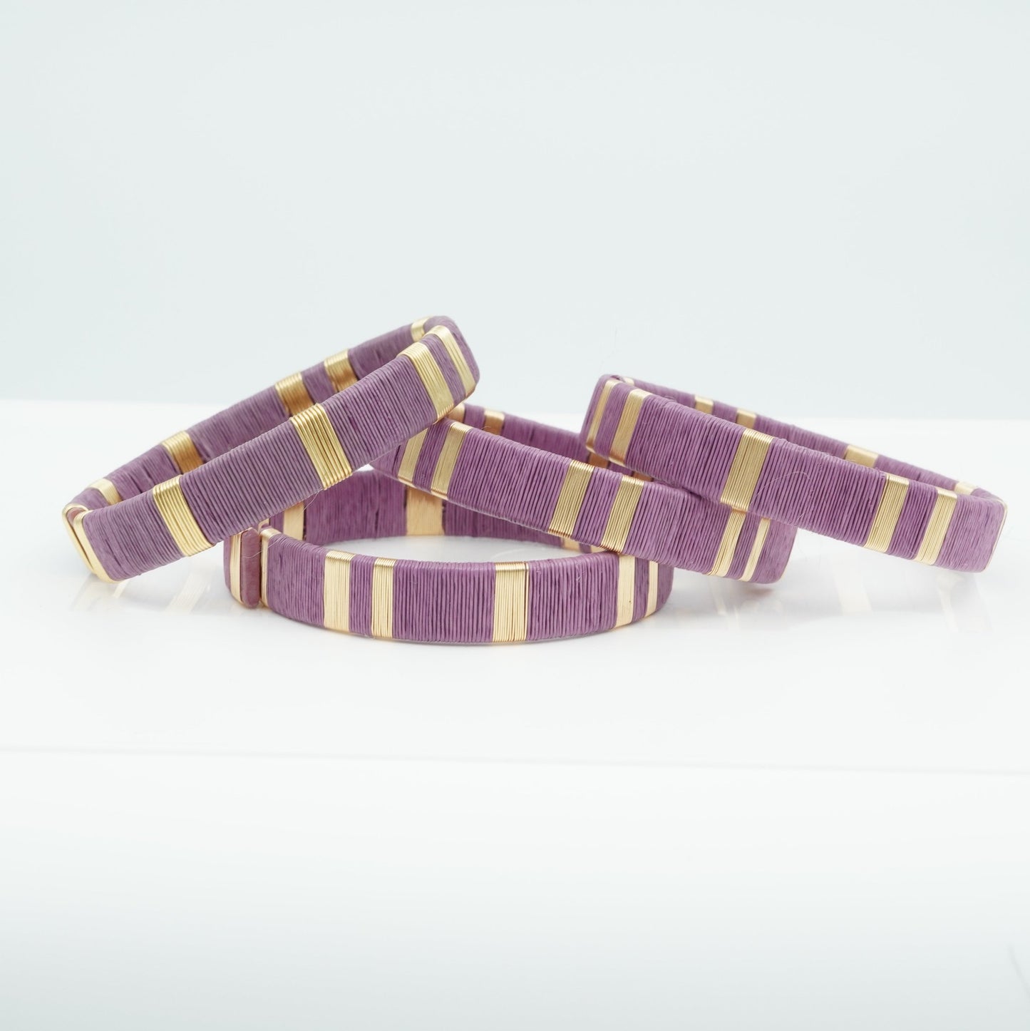 Bracelets made of lavender werregue palm fiber and gold wire.