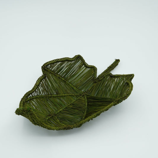 A green woven basket in the shape of a leaf.