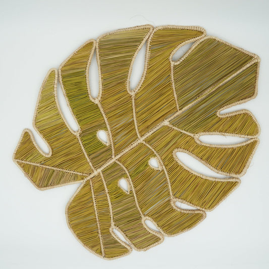 Overhead view of woven monstera leaf placemat.