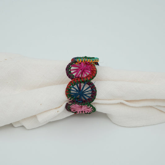 A side view of a multicolored woven napkin ring in a circle pattern.
