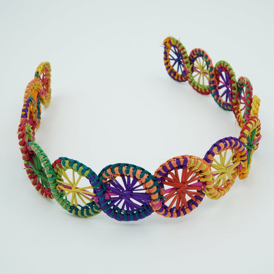 Multicolored headband in circle pattern made of iraca palm fiber.