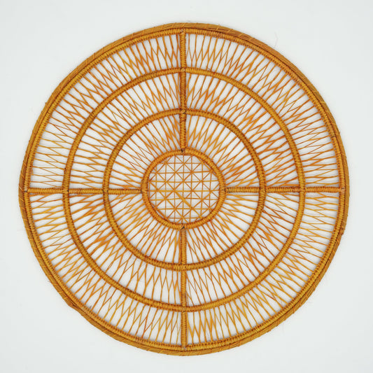 Overhead view of woven orange concentric circle placemat.