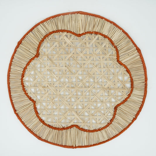 Overhead view of woven orange flower in border placemat