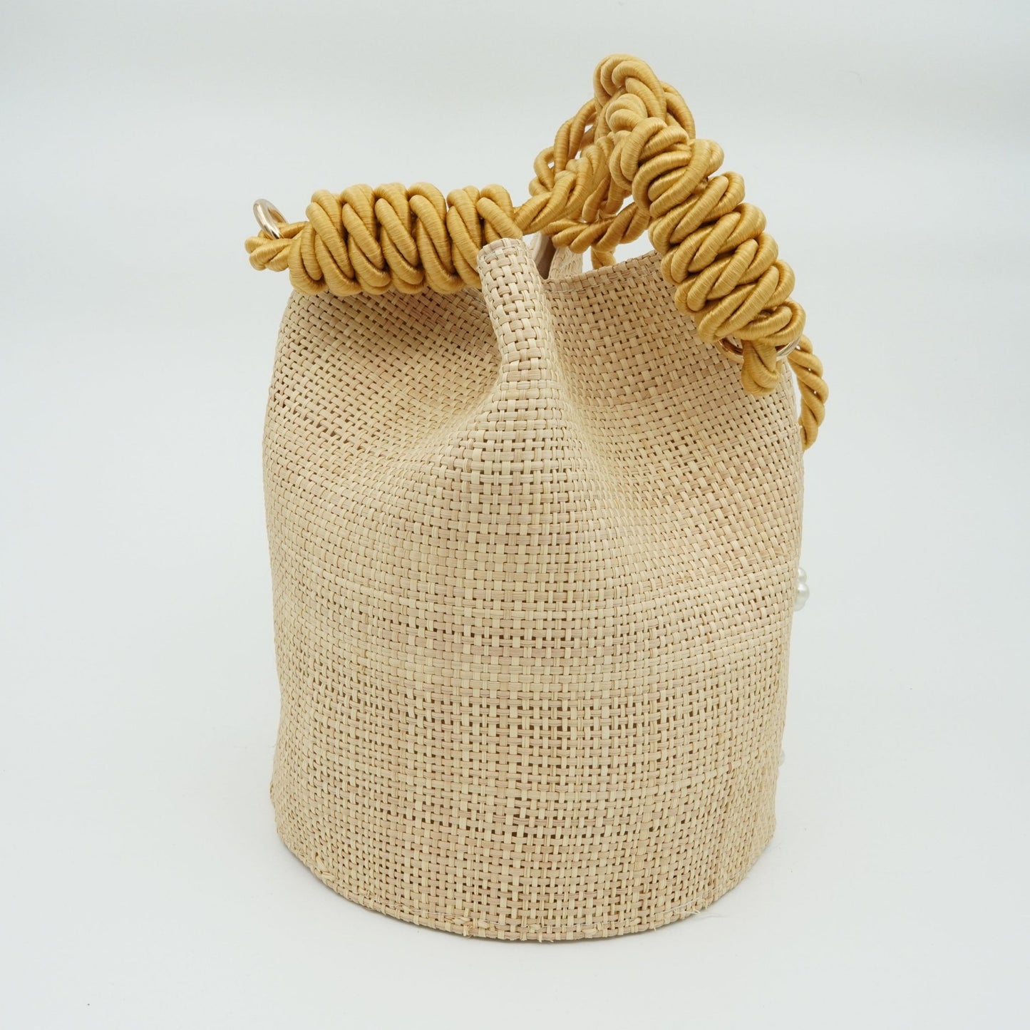 Back view of woven pearl bucket bag with gold strap.