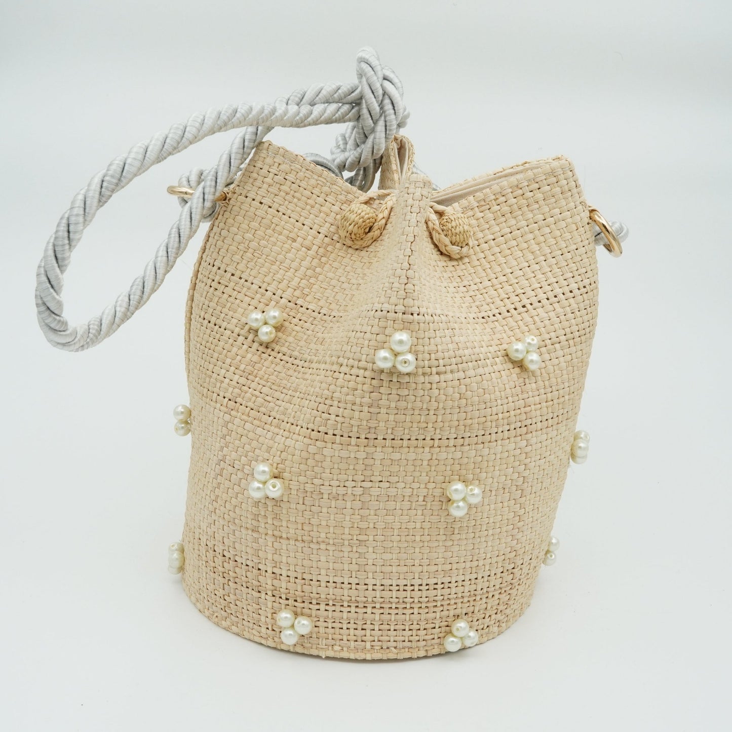 Woven pearl bucket bag with silver strap.