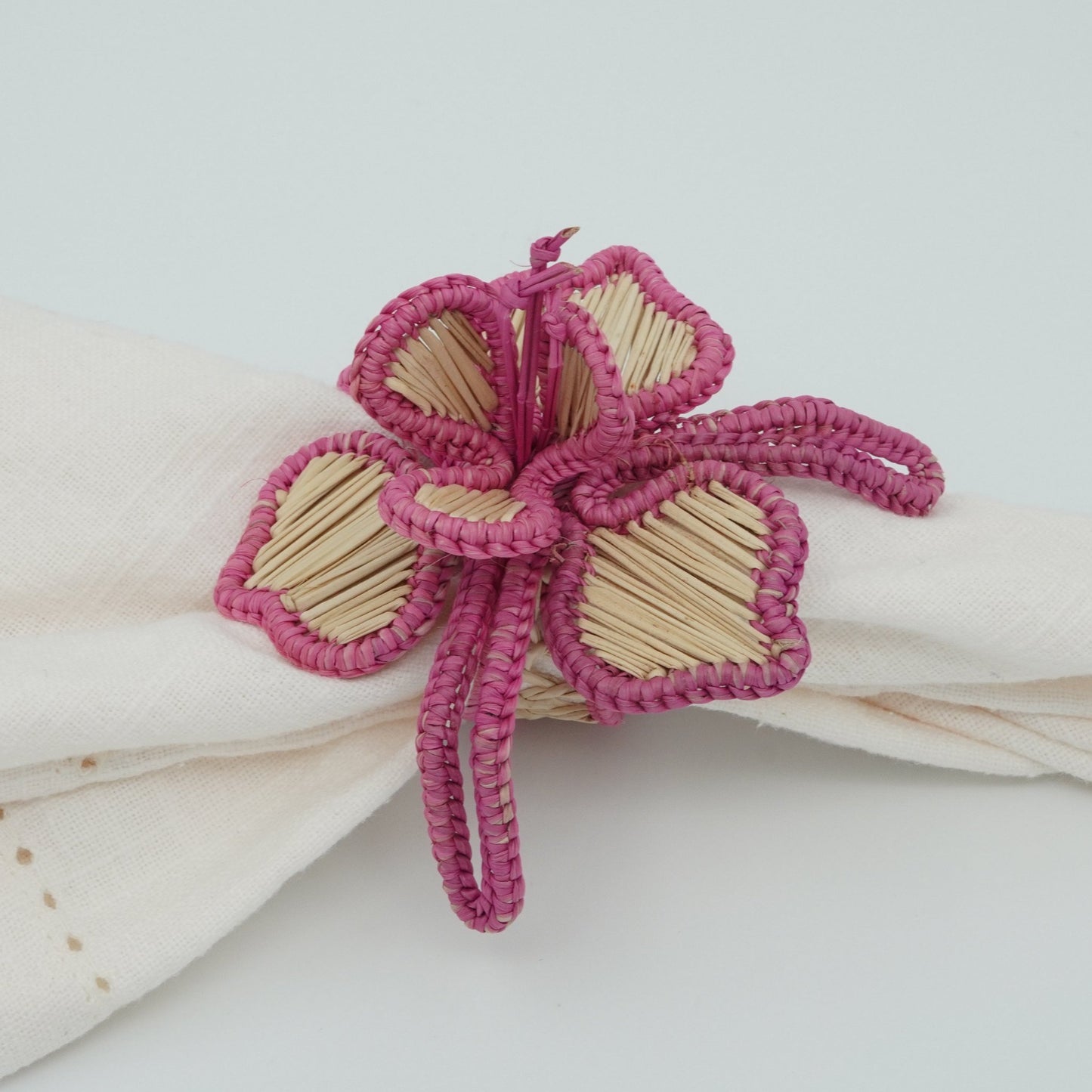 Side view of woven pink orchid napkin ring.