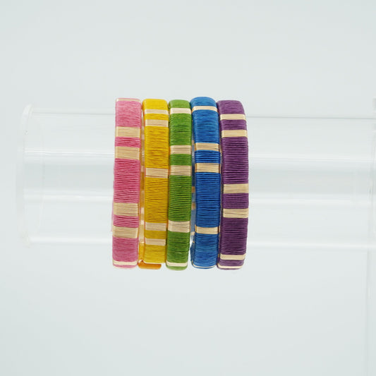 Bracelets made of werregue palm fiber and gold wire in pink, yellow, green, blue, and purple colors.