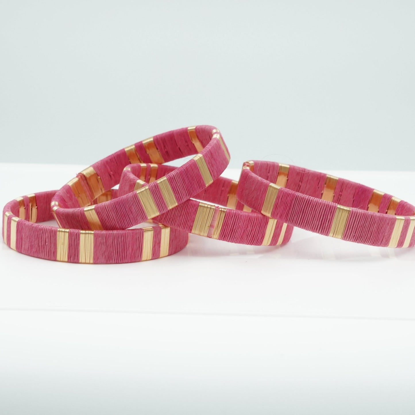Bracelets made of pink werregue palm fiber and gold wire.