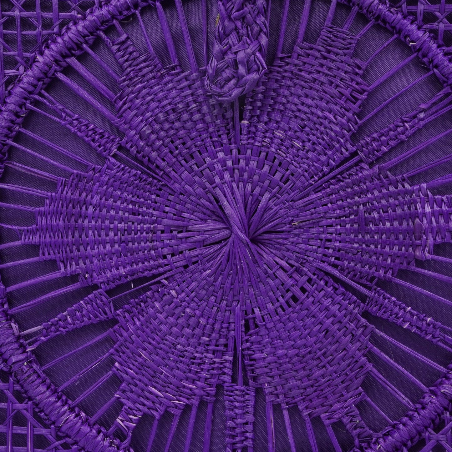 Close up view of purple woven square flower purse.
