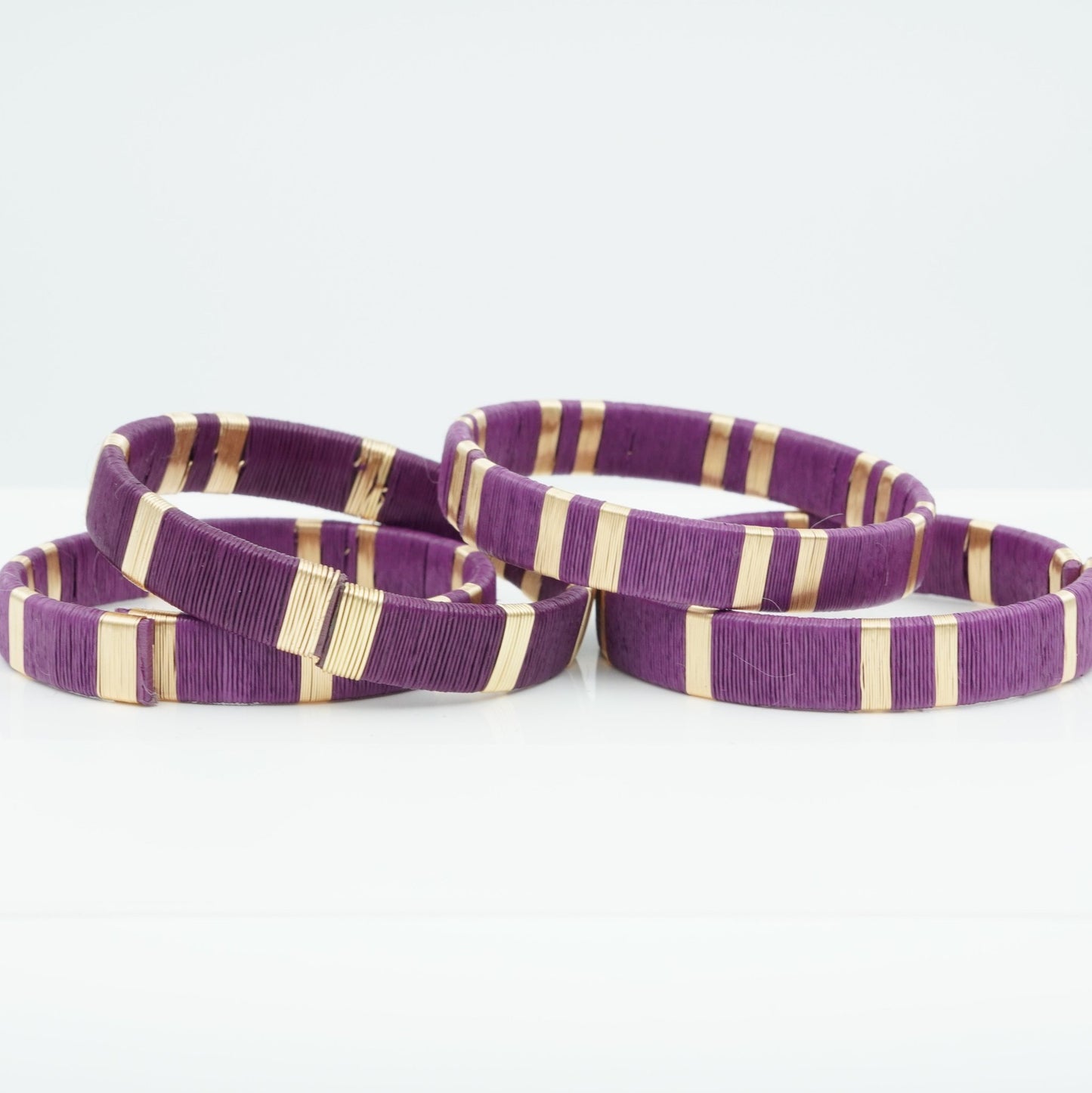 Bracelets made of purple werregue palm fiber and gold wire.