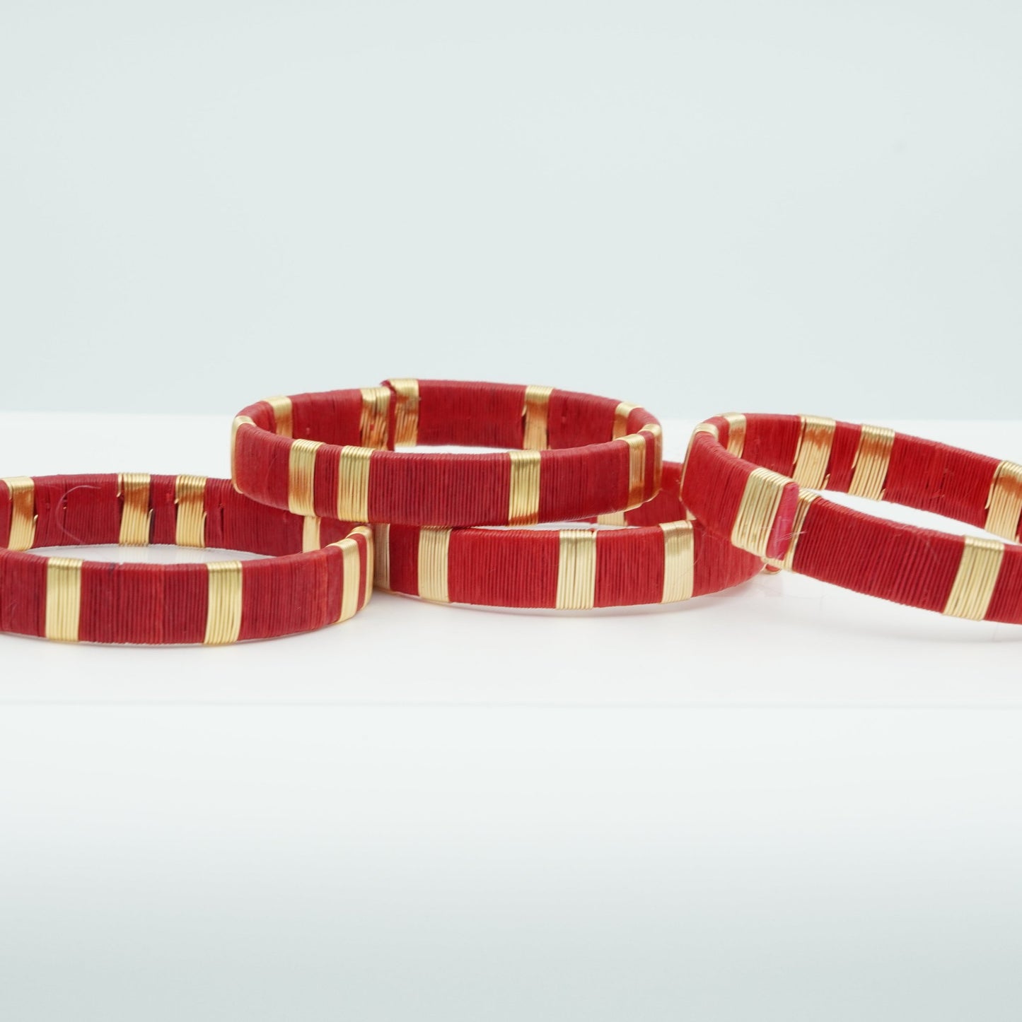 Bracelets made of red werregue palm fiber and gold wire.