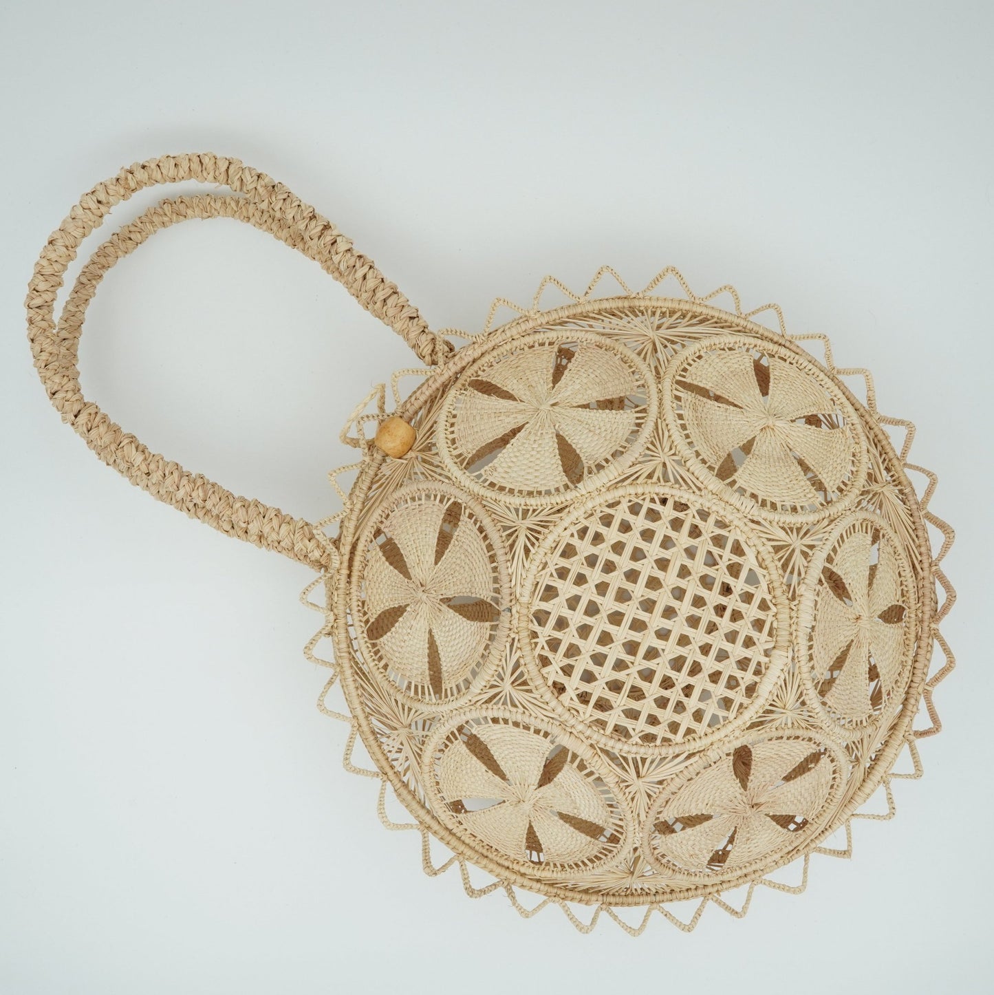 Round woven purse with flowers.