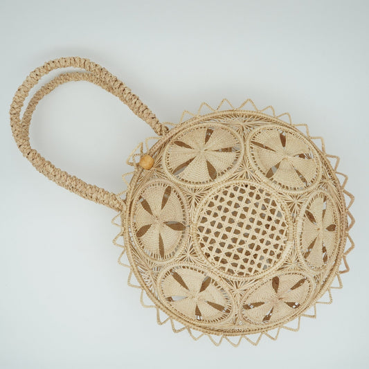 Round woven purse with flowers.