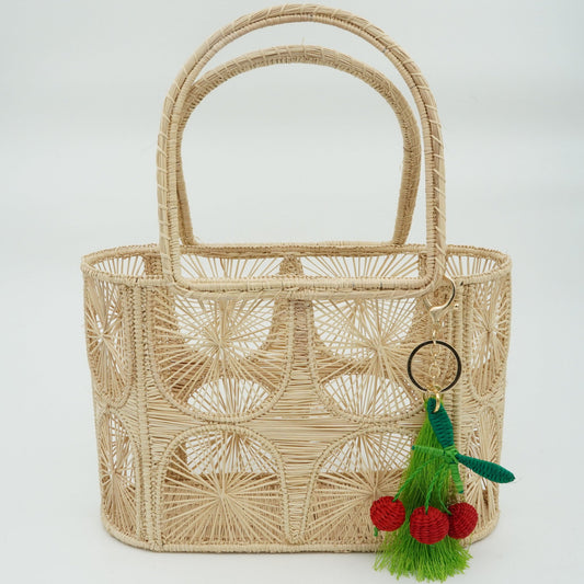 Woven purse with semicircle pattern featuring a cherry charm.