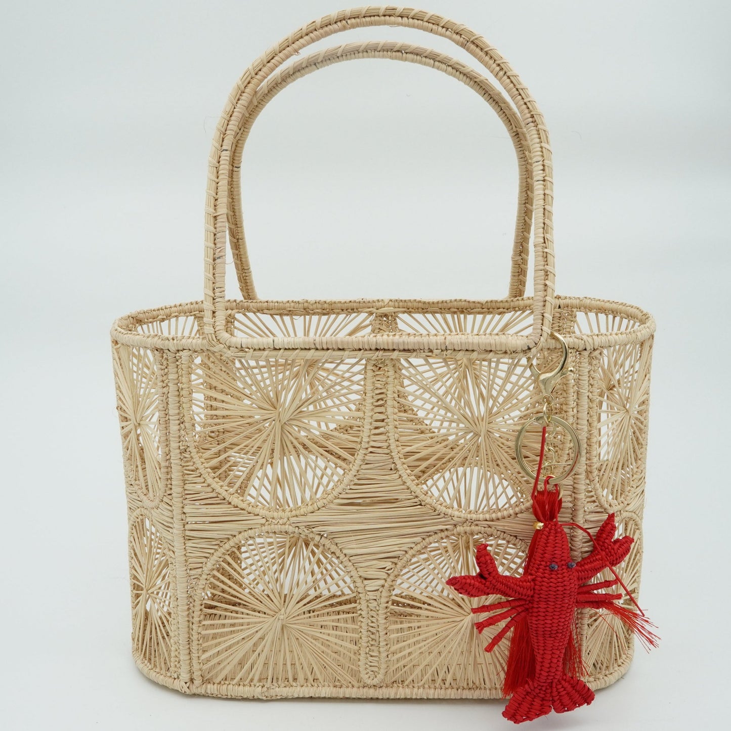 Woven purse with semicircle pattern featuring a lobster charm.