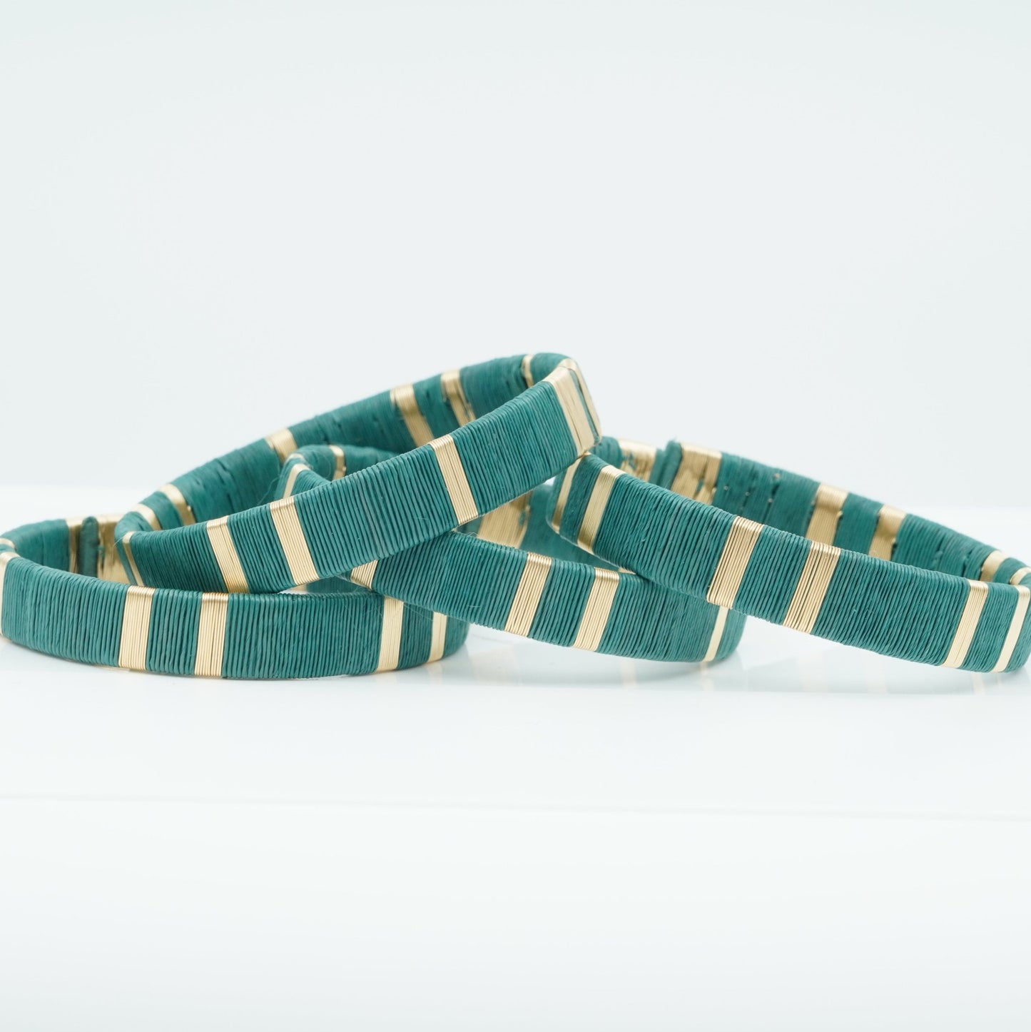 Bracelets made of turquoise werregue palm fiber and gold wire.