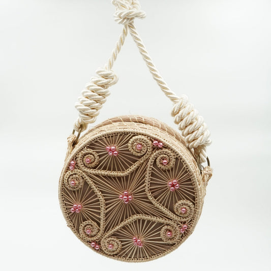 Woven yoyo purse with design with pink beads and white strap.