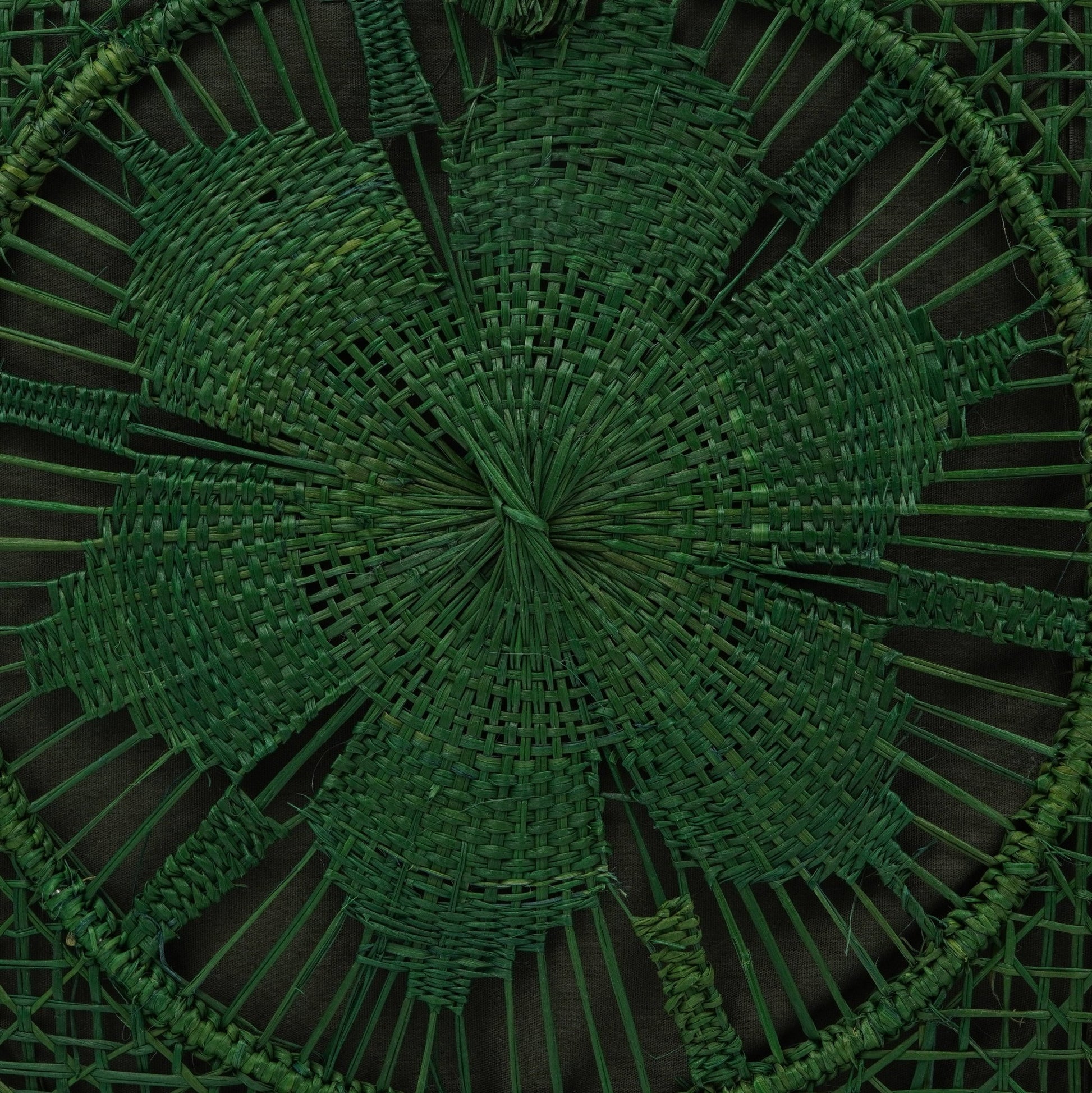 Close up view of green woven square flower purse.