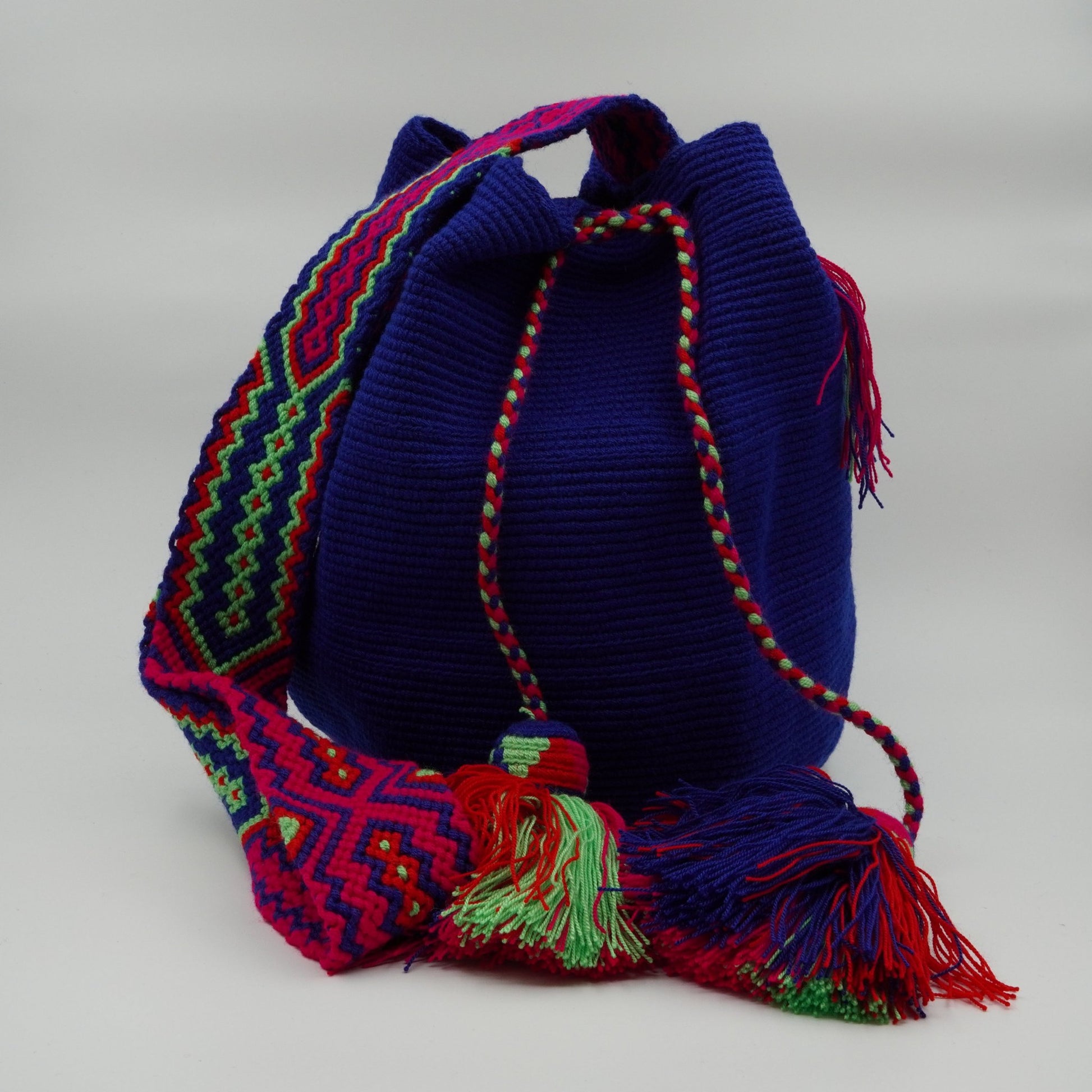 Large blue mochila woven handbag with pompoms.