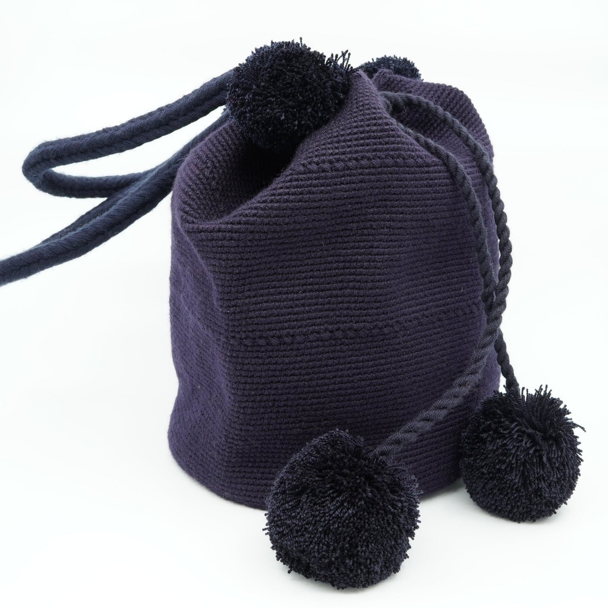 Large navy mochila woven handbag with pompoms.