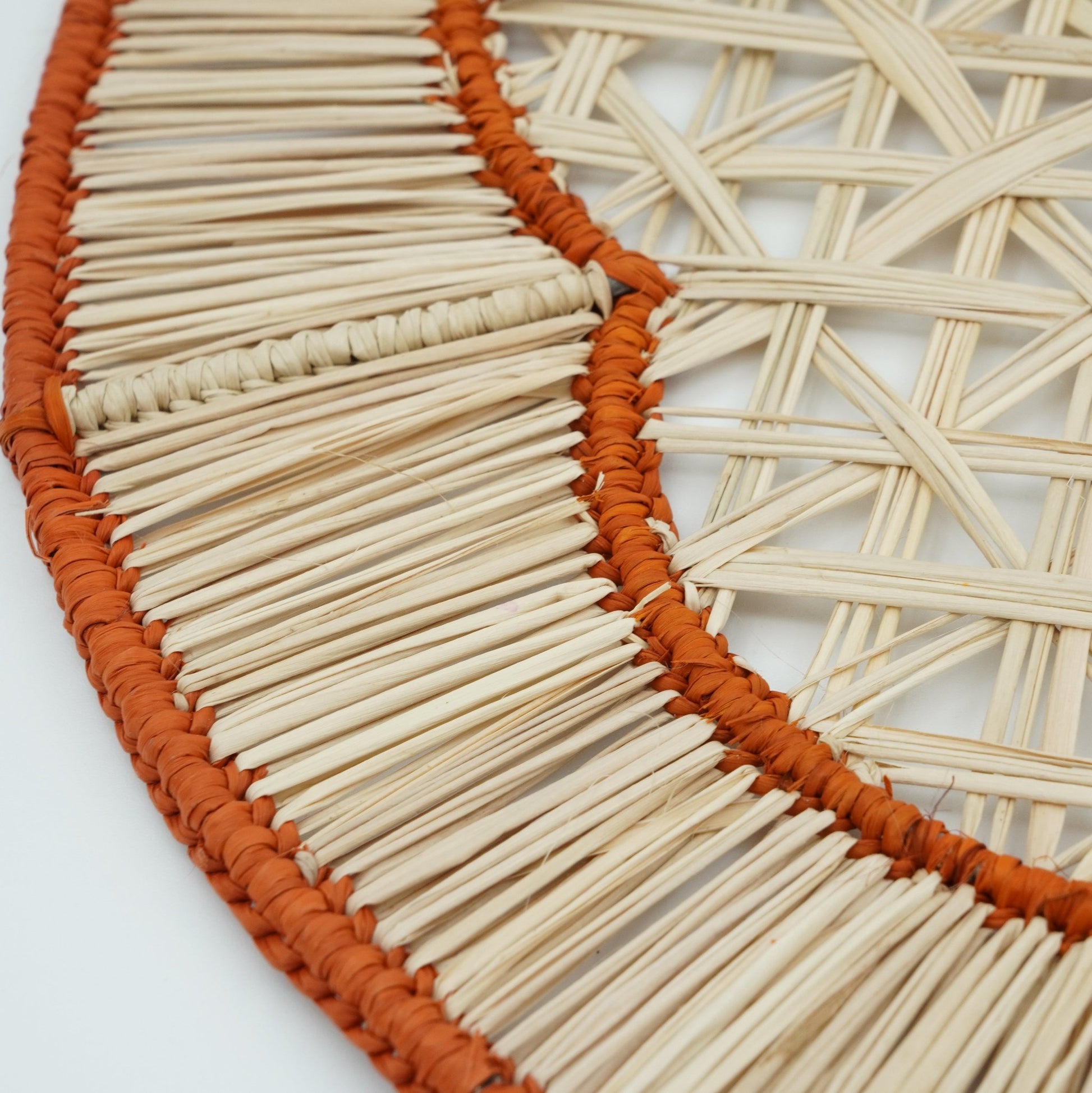 Close up view of woven orange flower in border placemat