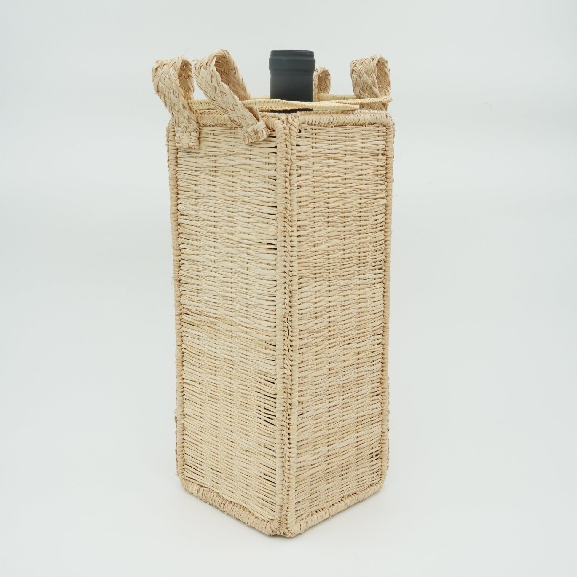 Head on view of solid square woven wine basket with wine.